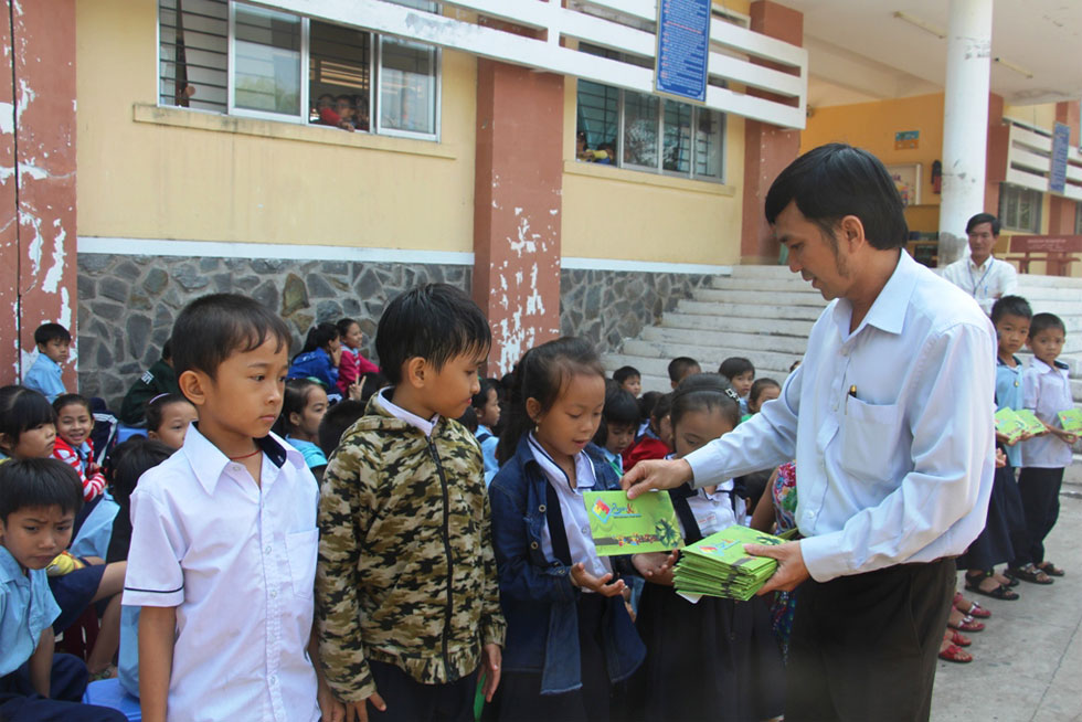 Đại diện lãnh đạo Công ty TNHH MTV Esquire Kids trao quà tết cho học sinh nghèo huyện Cần Giờ. 
